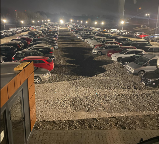 Oświetlony reflektorami LED plac Skyway Parking nocą – bezpieczny, monitorowany parking 24/7 przy lotnisku Chopina z nowoczesną infrastrukturą na 1000 aut.